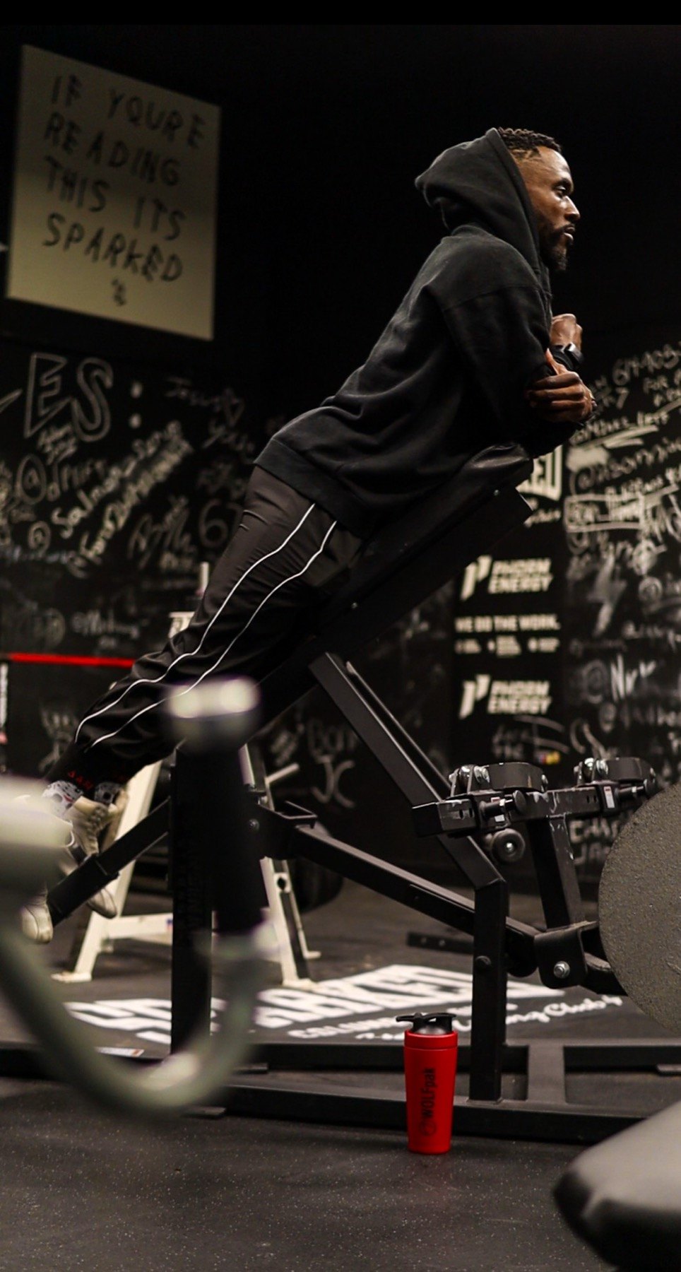 Athlete training on an incline bench in a dark gym