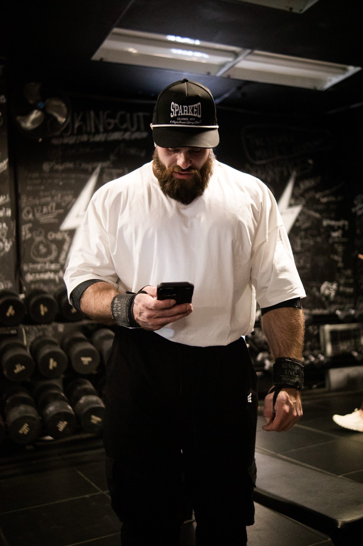 Russell Holland filming with a camera in a dark gym