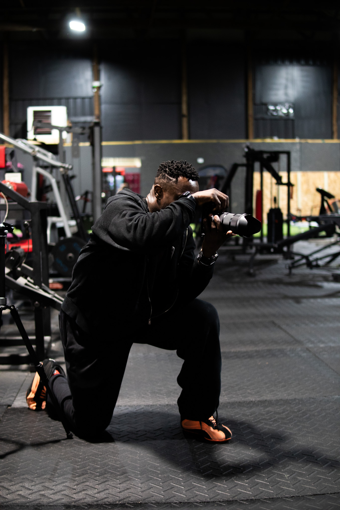 Russell Holland filming fitness content in a dark gym